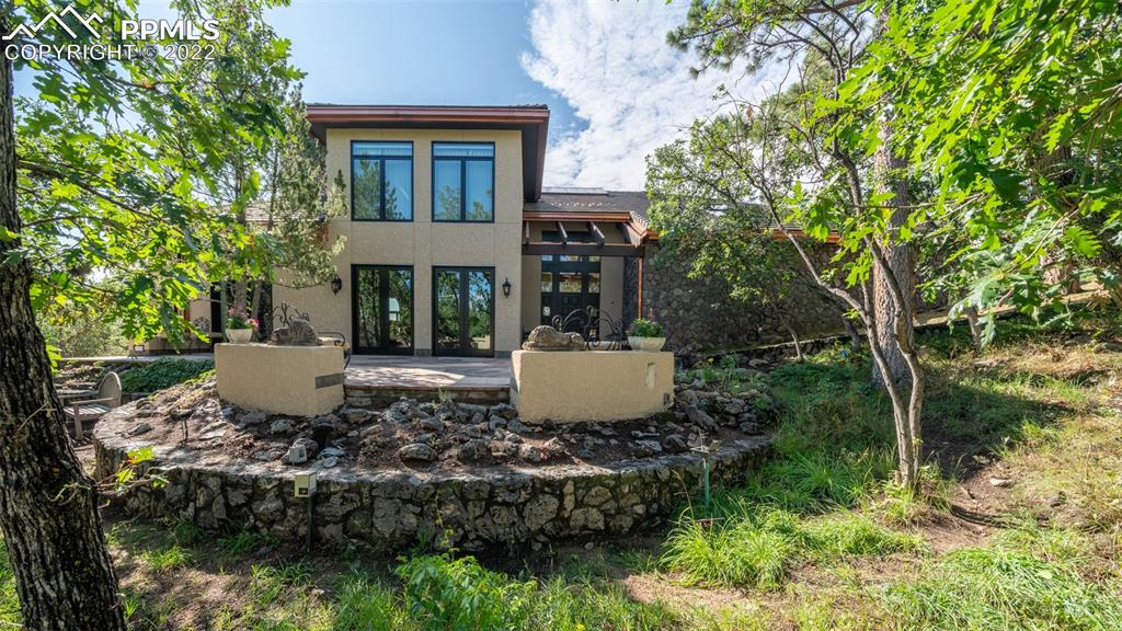 a view of a brick house with a yard and plants