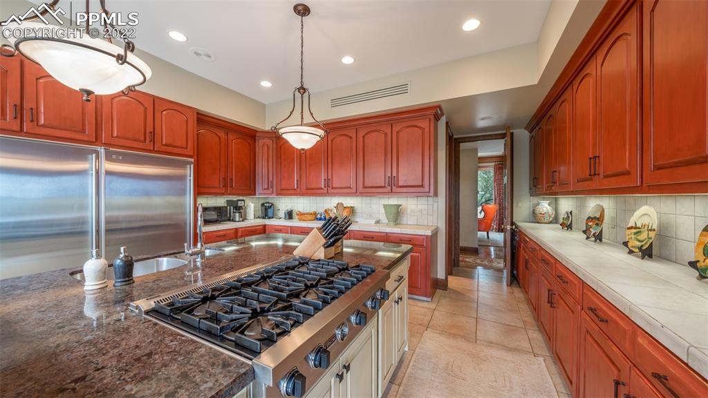 105 Marland Road Colorado Springs, CO 80906 - Photo 6 of 50 a kitchen with stainless steel appliances granite countertop a stove a sink dishwasher and a refrigerator with wooden cabinets