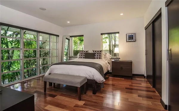 a bed sitting in a spacious bedroom next to a window