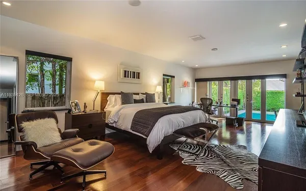a bedroom with a bed a couch and a large window