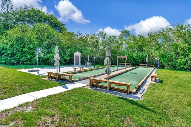 a view of a patio with table and chairs potted plants and large tree