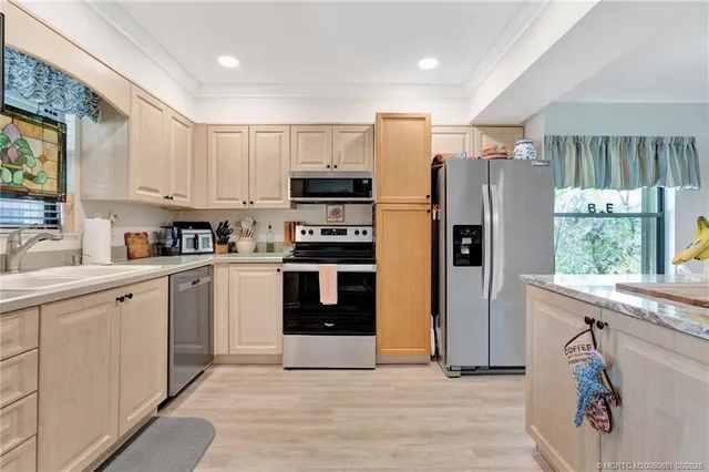 a kitchen with stainless steel appliances granite countertop a sink stove and refrigerator