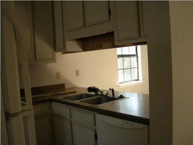 a kitchen with a sink cabinets and a window