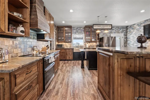 a kitchen with stainless steel appliances granite countertop lots of counter top space and wooden floor