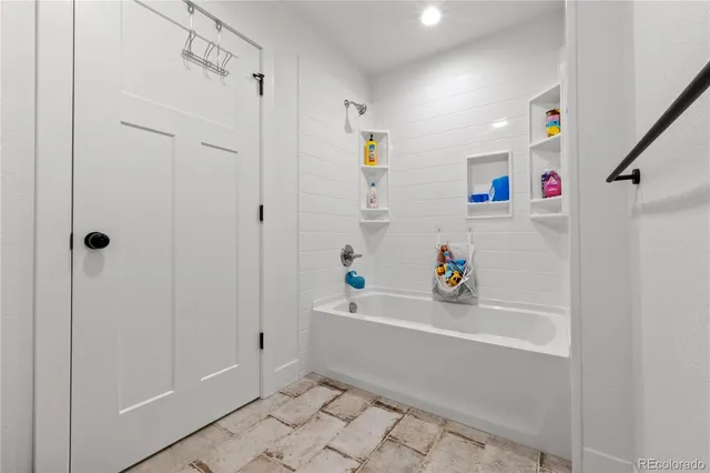 a white bath tub sitting next to a white sink and vanity