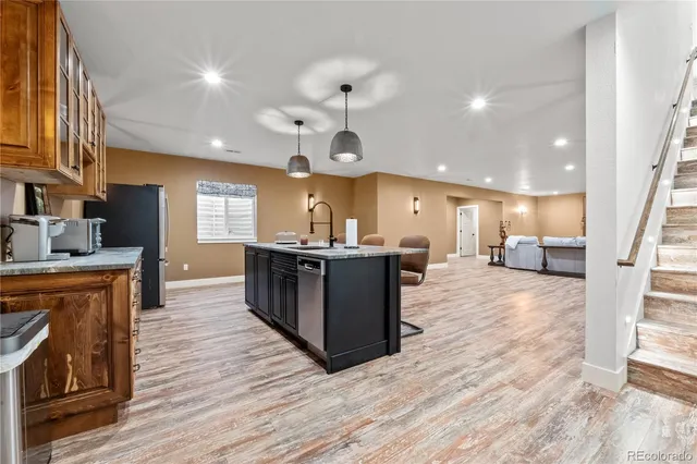 a large kitchen with stainless steel appliances kitchen island granite countertop a large counter top a sink a stove and a window