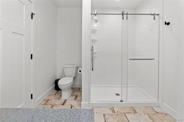 a bathroom with a toilet and a shower