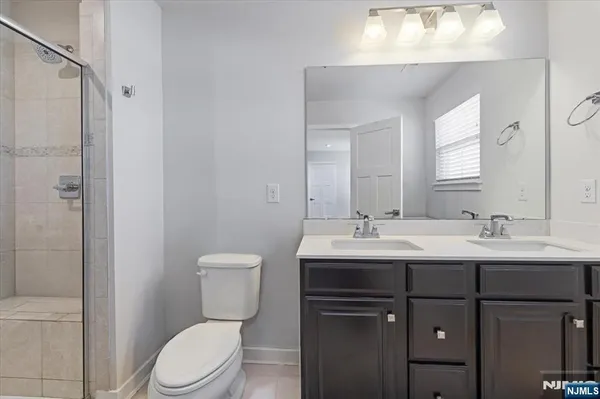 a bathroom with a toilet sink a mirror and shower