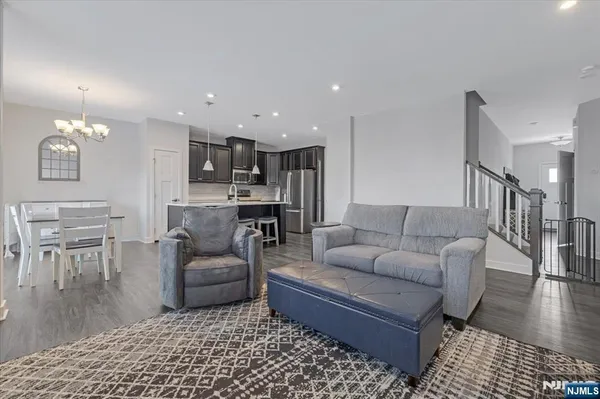 a living room with furniture and a dining table with wooden floor