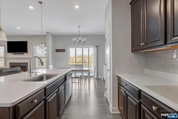 a kitchen with granite countertop a sink a counter top space appliances and cabinets