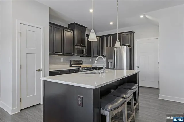 a kitchen with kitchen island a sink stove and refrigerator
