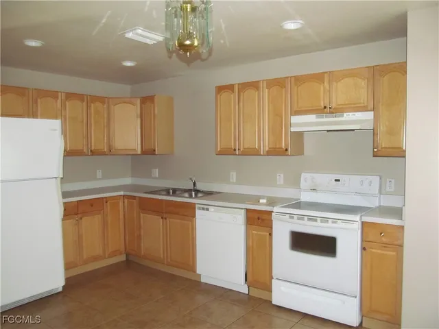 a kitchen with a stove sink and cabinets