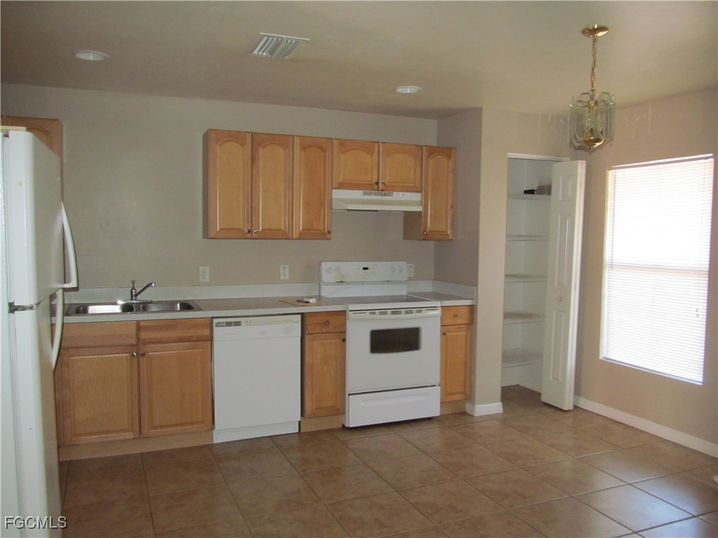 662 Alabama Road South Lehigh Acres, FL 33974 - Photo 3 of 11 a kitchen with a sink stove and cabinets