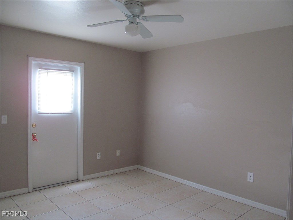662 Alabama Road South Lehigh Acres, FL 33974 - Photo 7 of 11 an empty room with a ceiling fan and a window