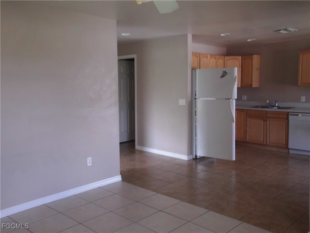 662 Alabama Road South Lehigh Acres, FL 33974 - Photo 9 of 11 an empty room with wooden floor kitchen view and a window