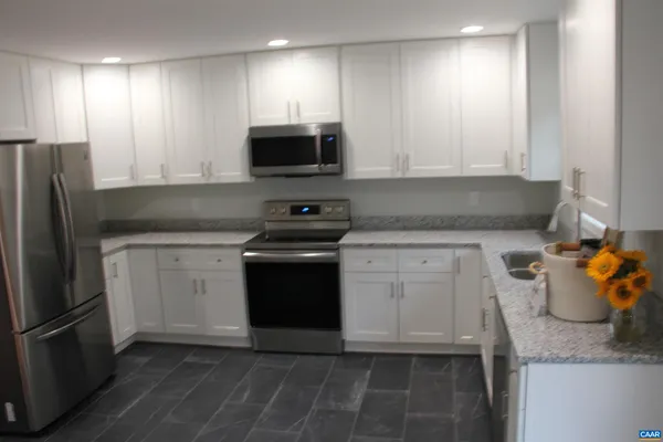 a kitchen with stainless steel appliances white cabinets and a refrigerator