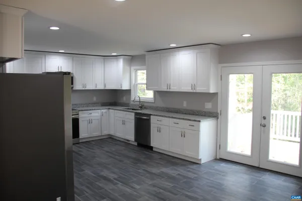 a kitchen with granite countertop white cabinets and white appliances
