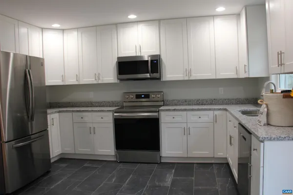 a kitchen with stainless steel appliances granite countertop a refrigerator sink and cabinets