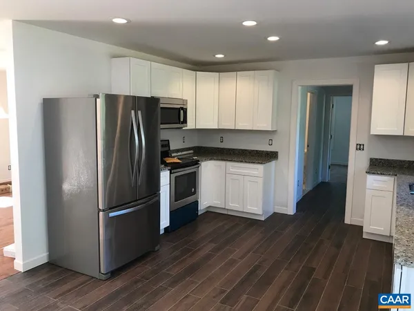 a kitchen with a refrigerator a sink and cabinets