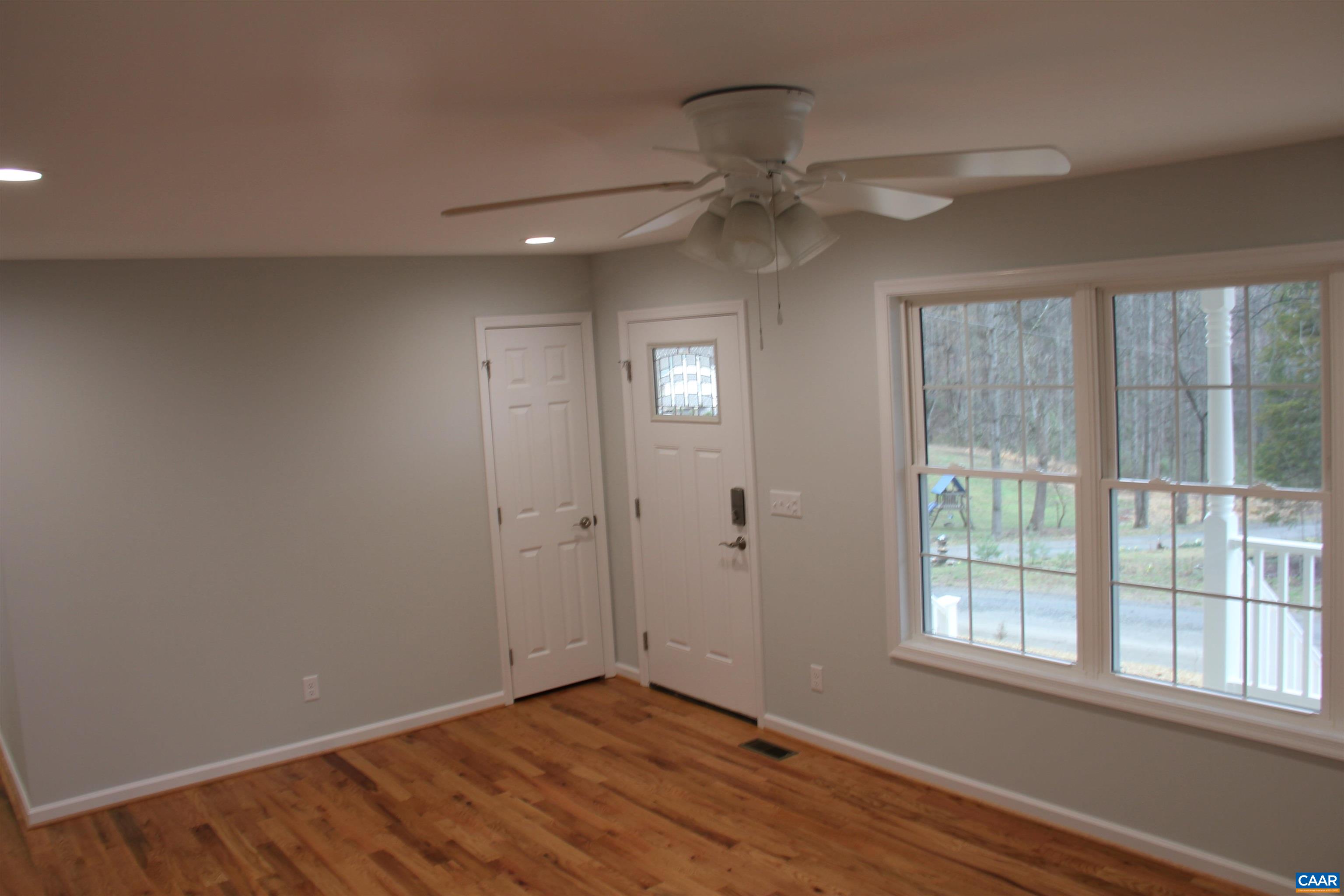 672 Westwood Road Stanardsville, VA 22973 - Photo 20 of 31 an empty room with wooden floor fan and windows