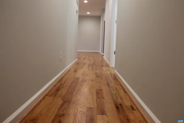 a view of a hallway with wooden floor