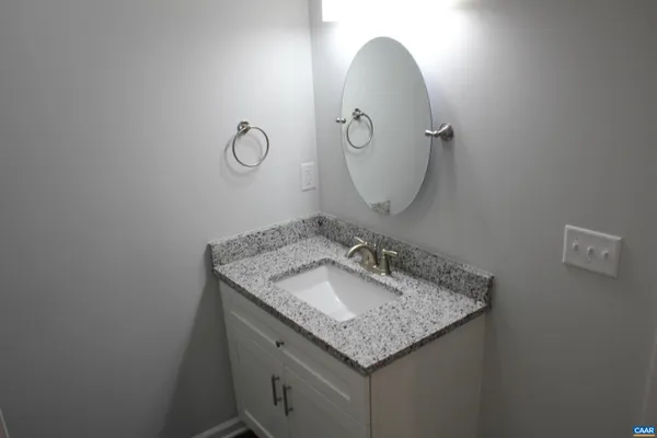a bathroom with a granite countertop sink and a mirror