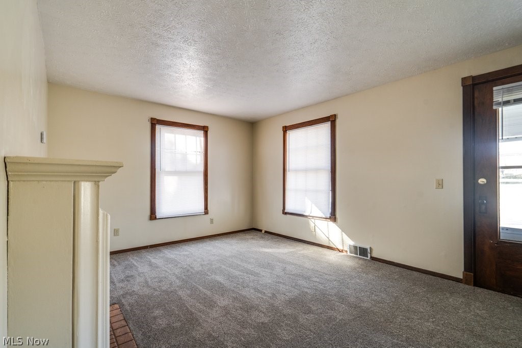 3693 Fishcreek Road Stow, OH 44224 - Photo 12 of 23 Carpeted empty room featuring a textured ceiling and plenty of natural light