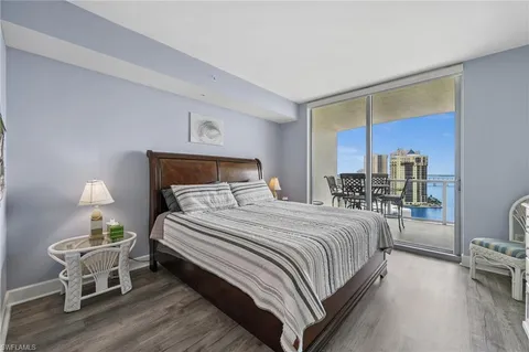 a bedroom with bed and a potted plant with wooden floor