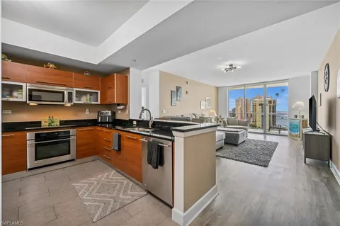 a kitchen with stainless steel appliances granite countertop a stove refrigerator and a sink