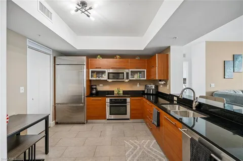 a kitchen with stainless steel appliances granite countertop a stove top oven a sink dishwasher a dining table and chairs