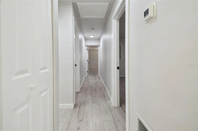 an empty room with wooden floor ceiling fan and windows