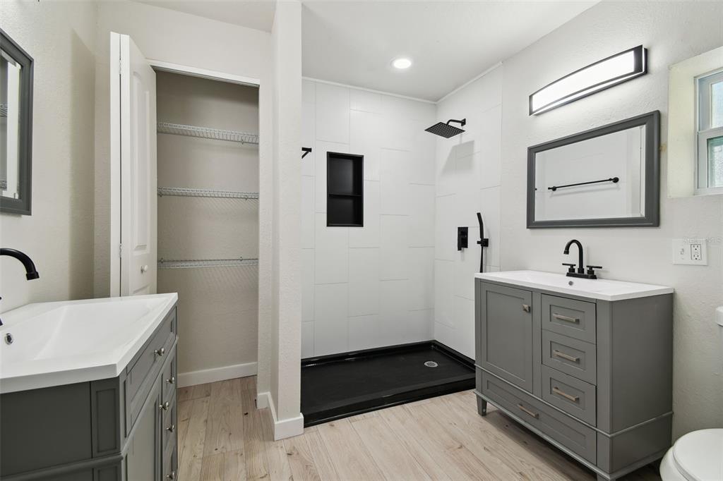 3414 Lindsey Street Dover, FL 33527 - Photo 25 of 45 a bathroom with a double vanity sink a mirror and shower