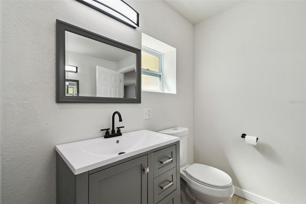 3414 Lindsey Street Dover, FL 33527 - Photo 27 of 45 a bathroom with a toilet a sink and mirror