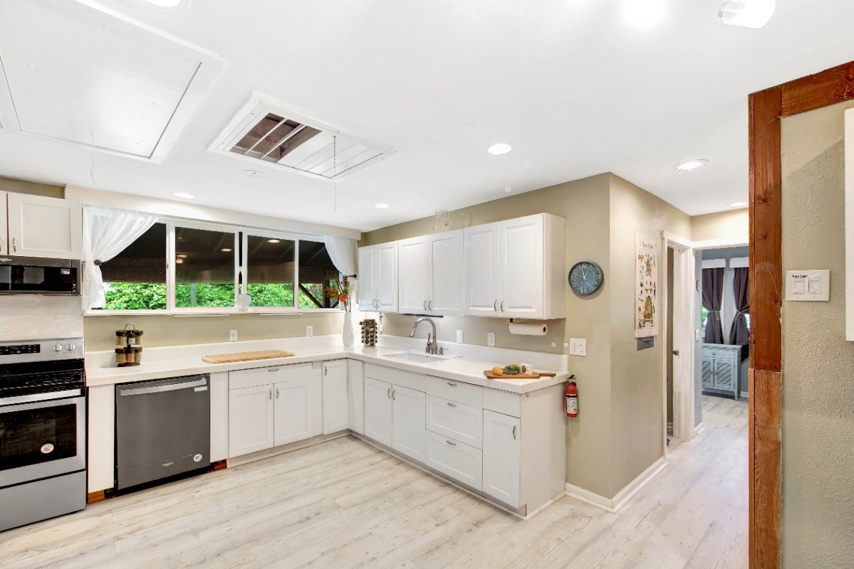 3590 Moloaa Road Kilauea, HI 96754 - Photo 6 of 22 a large kitchen with stainless steel appliances kitchen island granite countertop a sink and cabinets