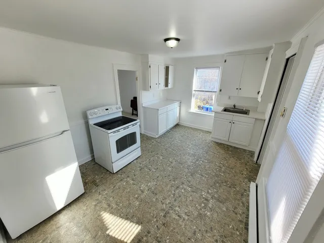 a kitchen with a sink and white cabinets