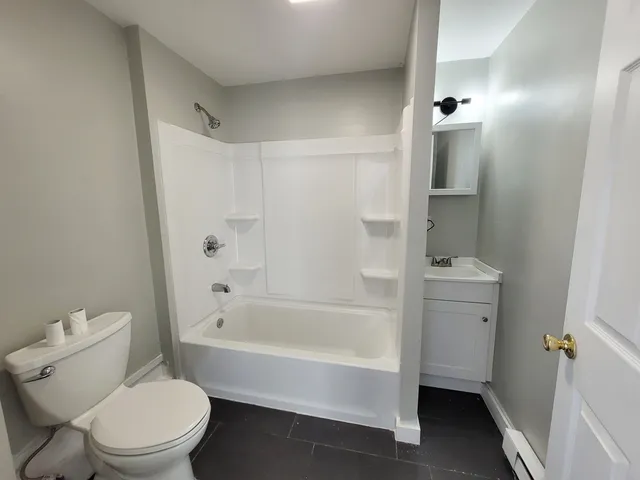 a white toilet sitting next to a bath tub