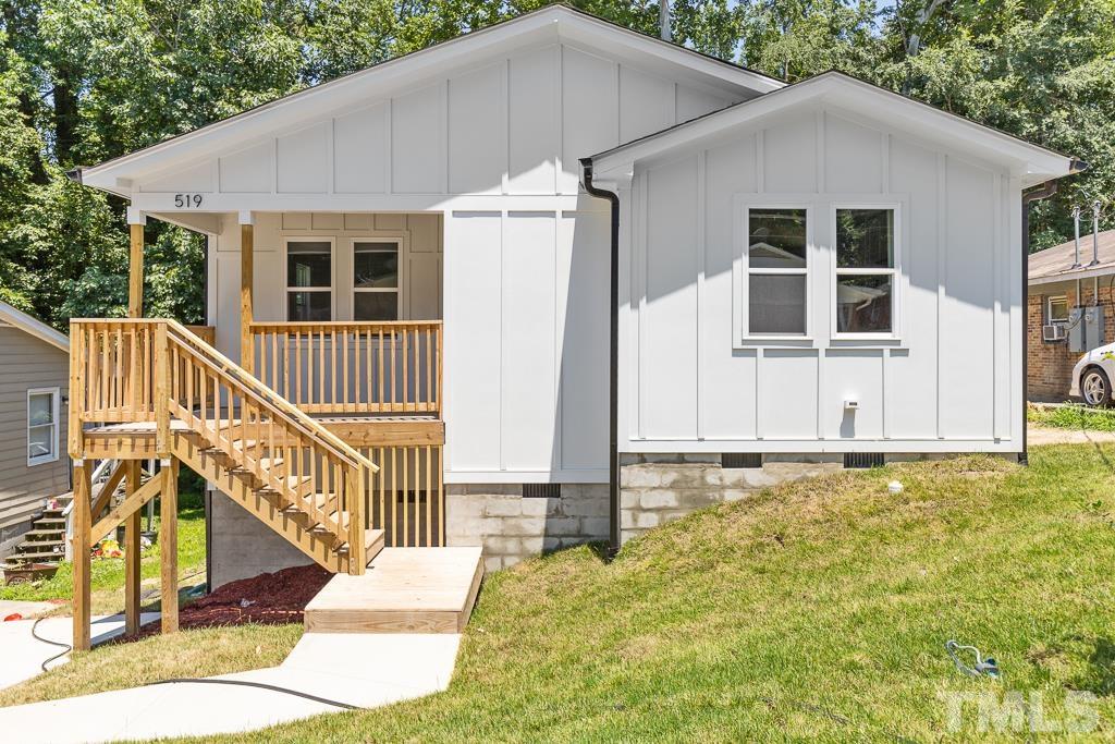 a white house with a large window and wooden fence