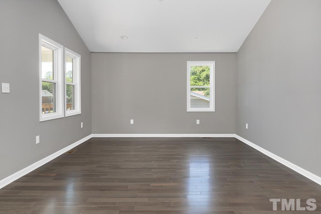 519 Barton Street Durham, NC 27707 - Photo 4 of 9 a view of an empty room with wooden floor and a window
