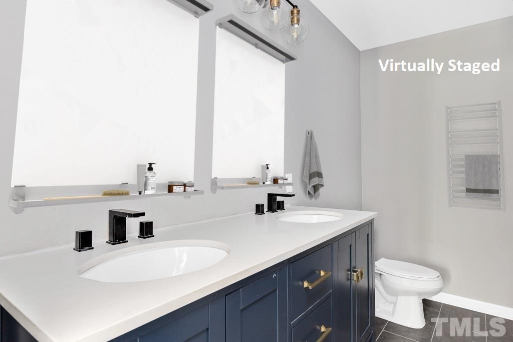 519 Barton Street Durham, NC 27707 - Photo 7 of 9 a bathroom with a double vanity sink toilet and mirror