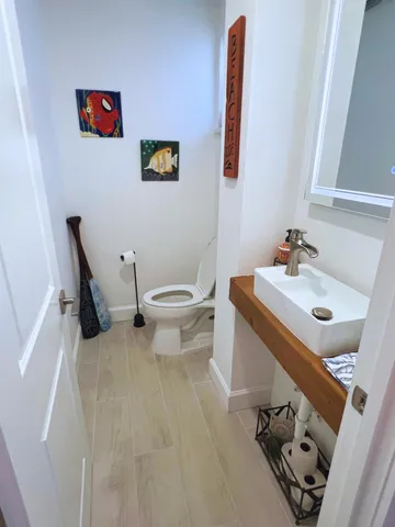 a bathroom with a sink mirror and toilet
