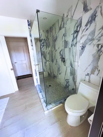 a bathroom with a toilet and a shower