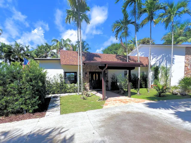a view of a chairs and table in the patio next to a yard