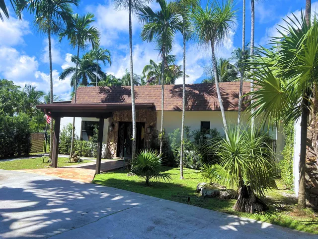 a front view of house with yard and swimming pool