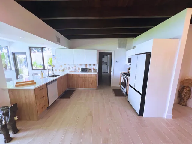 a large kitchen with lot of wooden cabinets and stainless steel appliances