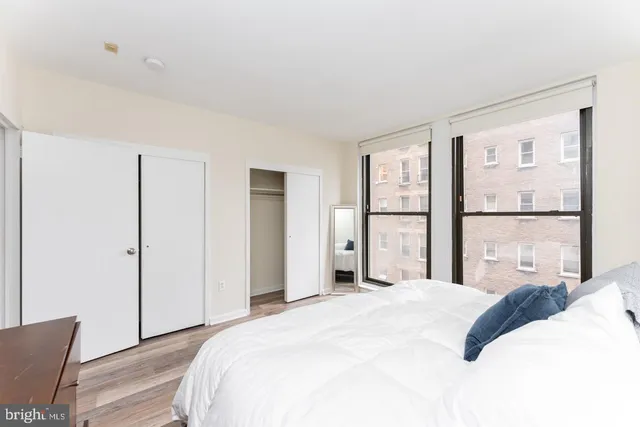 a bedroom with a bed and a large window