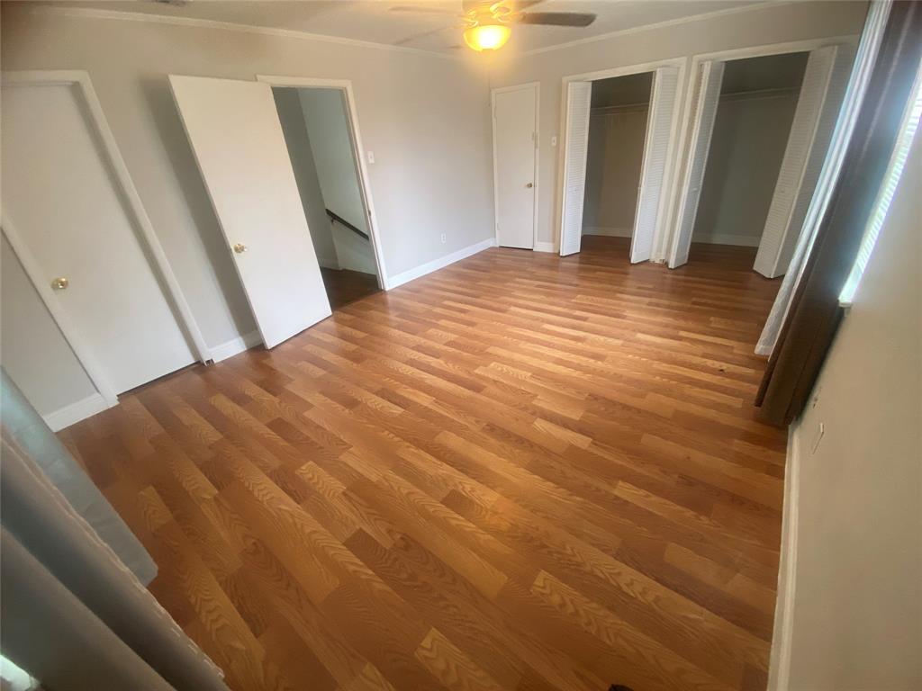 2133 Pleasant Drive Dallas, TX 75227 - Photo 19 of 40 Unfurnished bedroom featuring multiple closets, light wood-style floors, ceiling fan, and ornamental molding