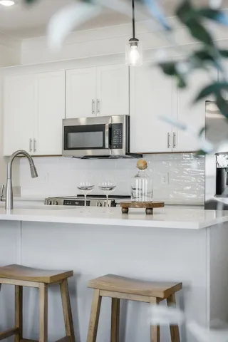 a kitchen with stainless steel appliances a sink a stove a microwave and wooden cabinets