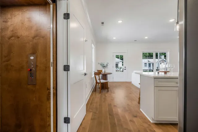 a view of a hallway with dining room and wooden floor