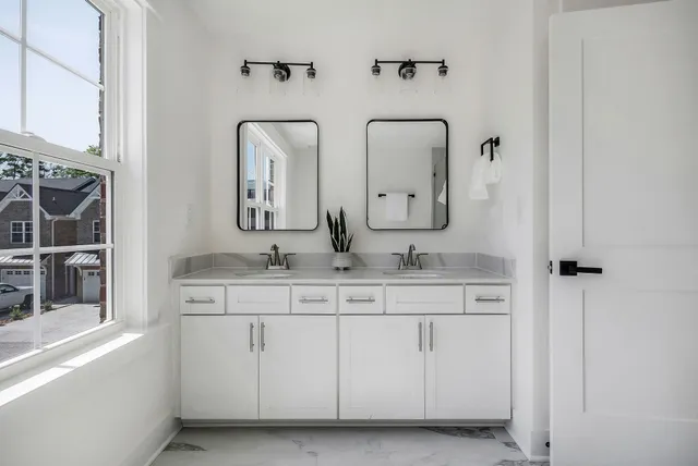 a bathroom with double vanity sinks and a mirror