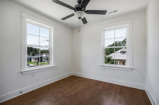 an empty room with a window and a ceiling fan